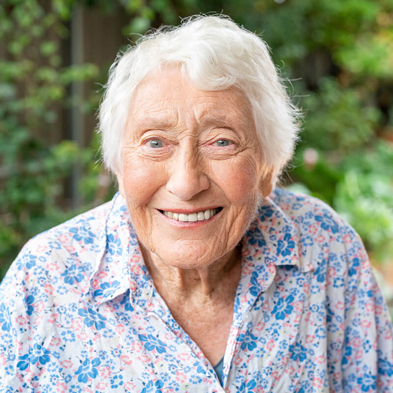 Front on portrait photography of an aged care customer smiling