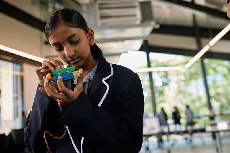 A primary school student engaged in an electronics project