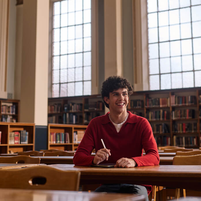 Young person photographed working in the library