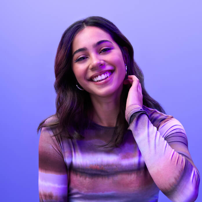 A young woman photographed in studio with a coloured background
